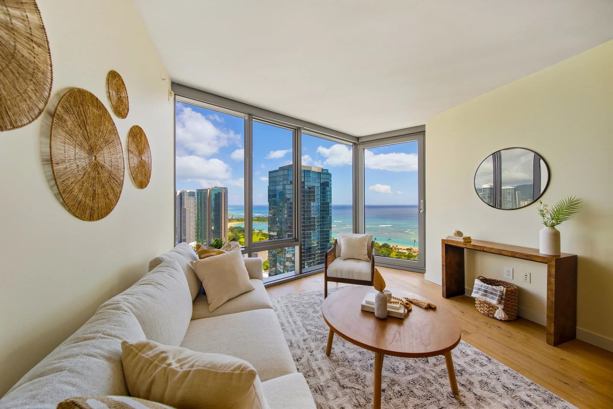 Living room with an operable floor-to-ceiling window opening to city and ocean views.