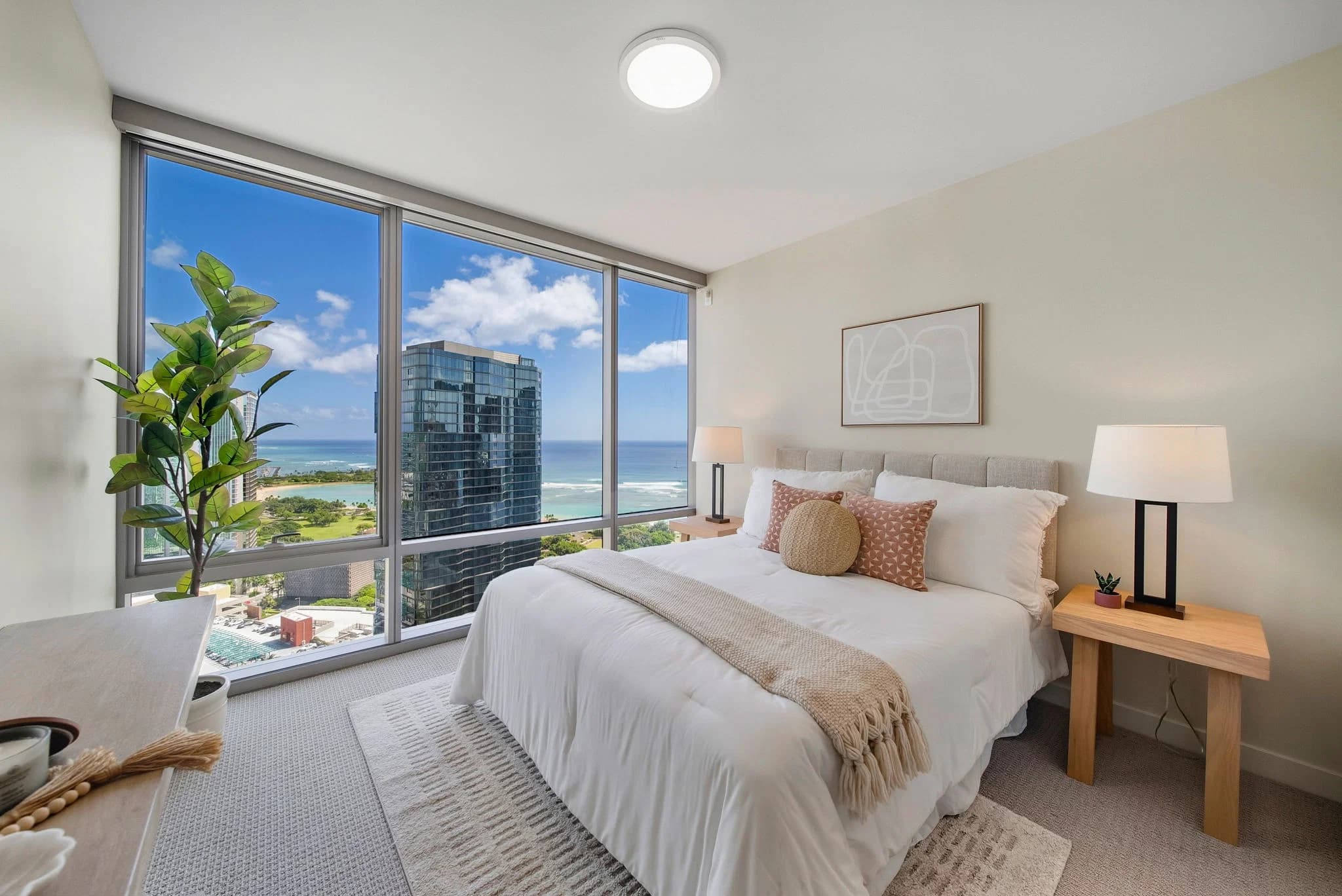 Bedroom with floor-to-ceiling corner windows and city views.