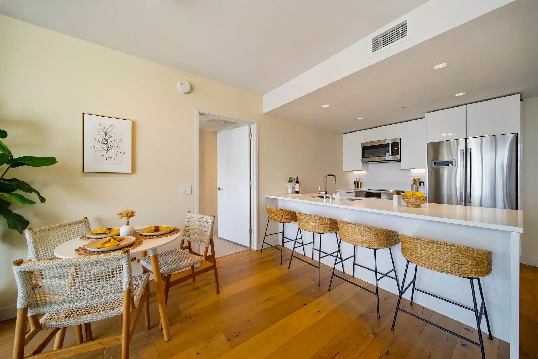 Eat-in kitchen with breakfast-bar seating, stainless appliances, and an adjacent dining area.