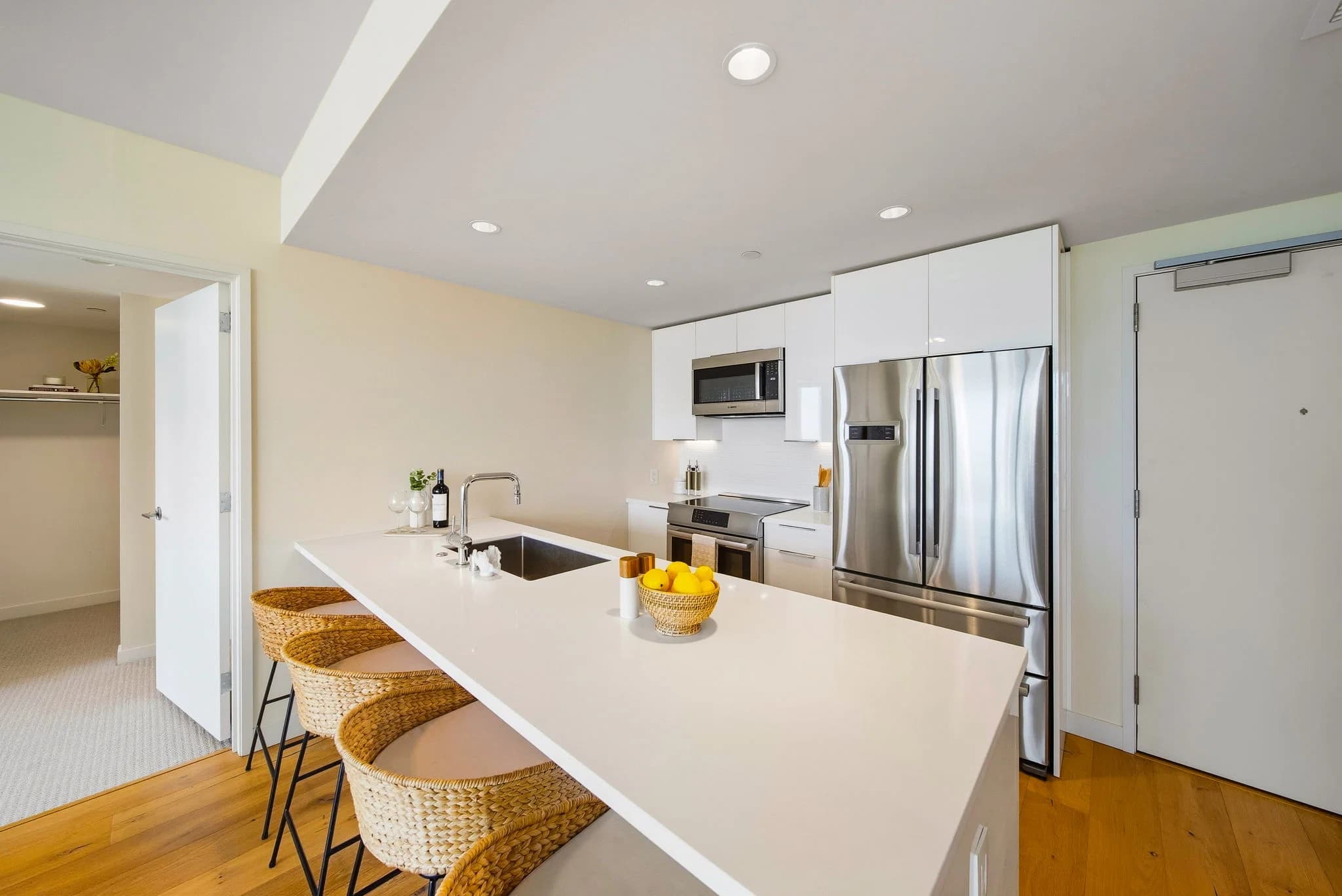 Kitchen with a large island, stainless appliances, and bar seating.