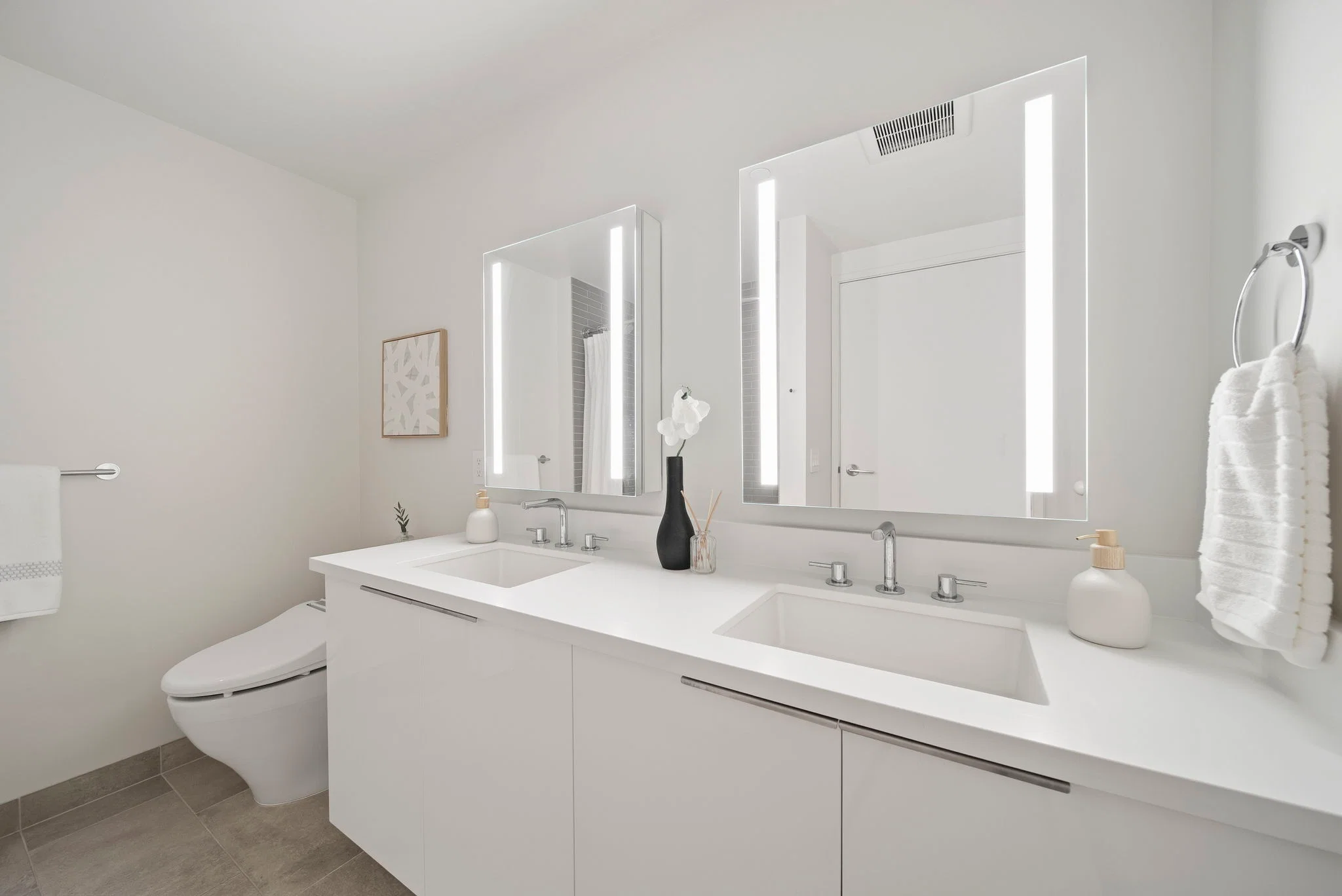 Bathroom with a dual vanity, backlit mirrors, and contemporary finishes.