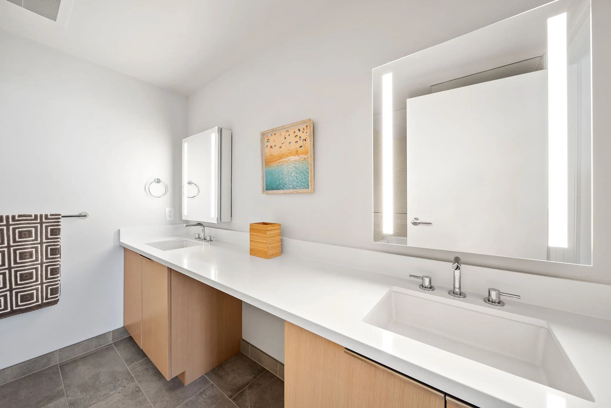 Double vanity bathroom with illuminated mirrors